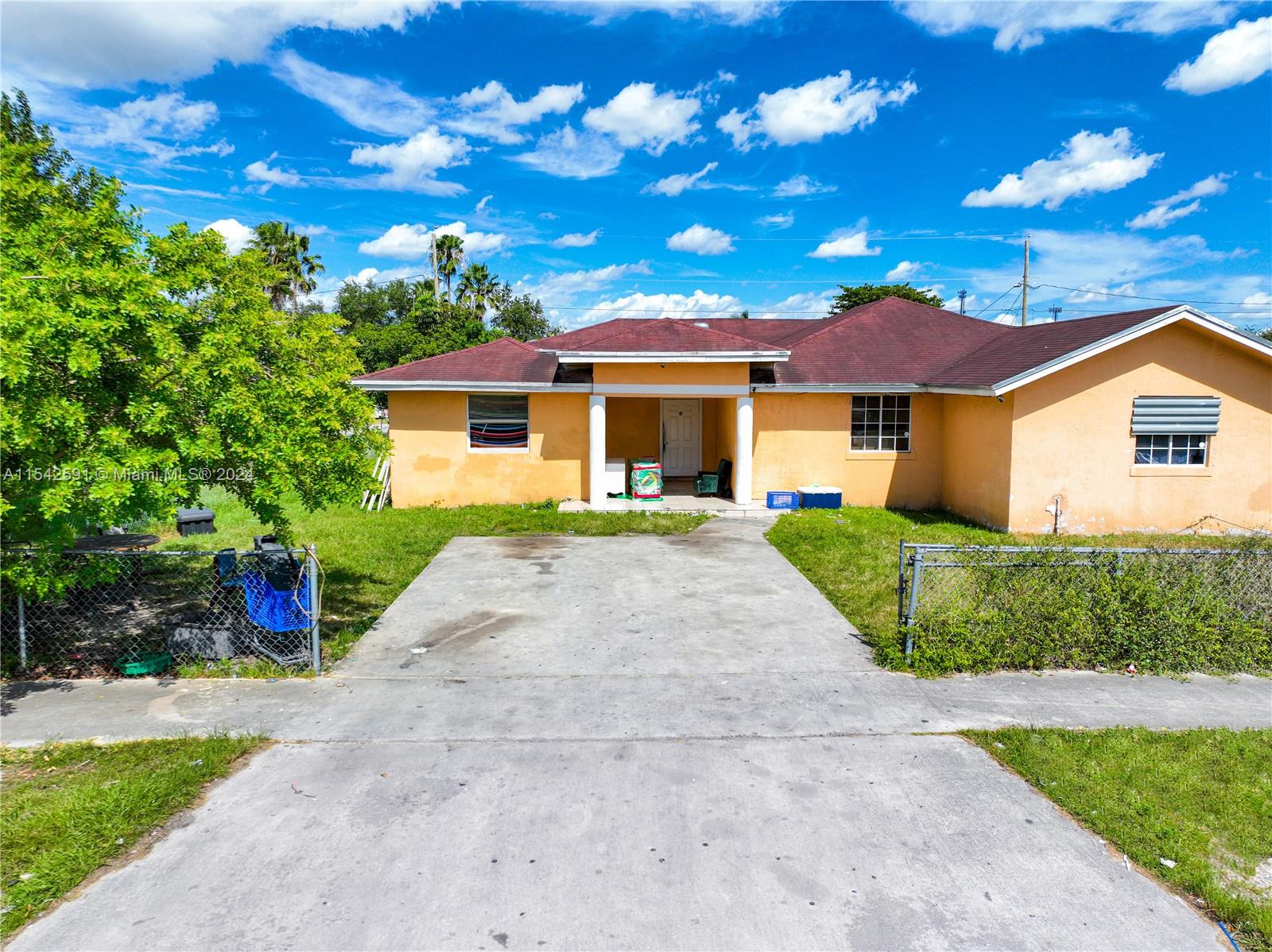 657 Southwest 7th Street Homestead, FL 33030 - Photo 11 of 33 a front view of a house with a yard and garage