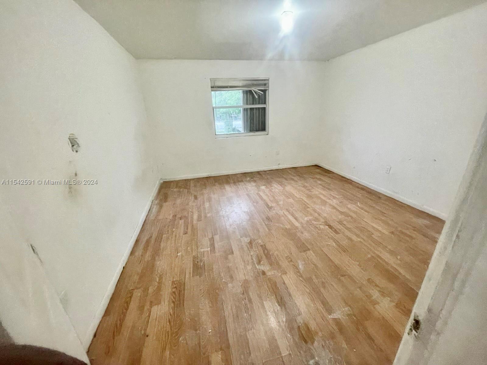 657 Southwest 7th Street Homestead, FL 33030 - Photo 12 of 33 a view of a room with wooden floor and window