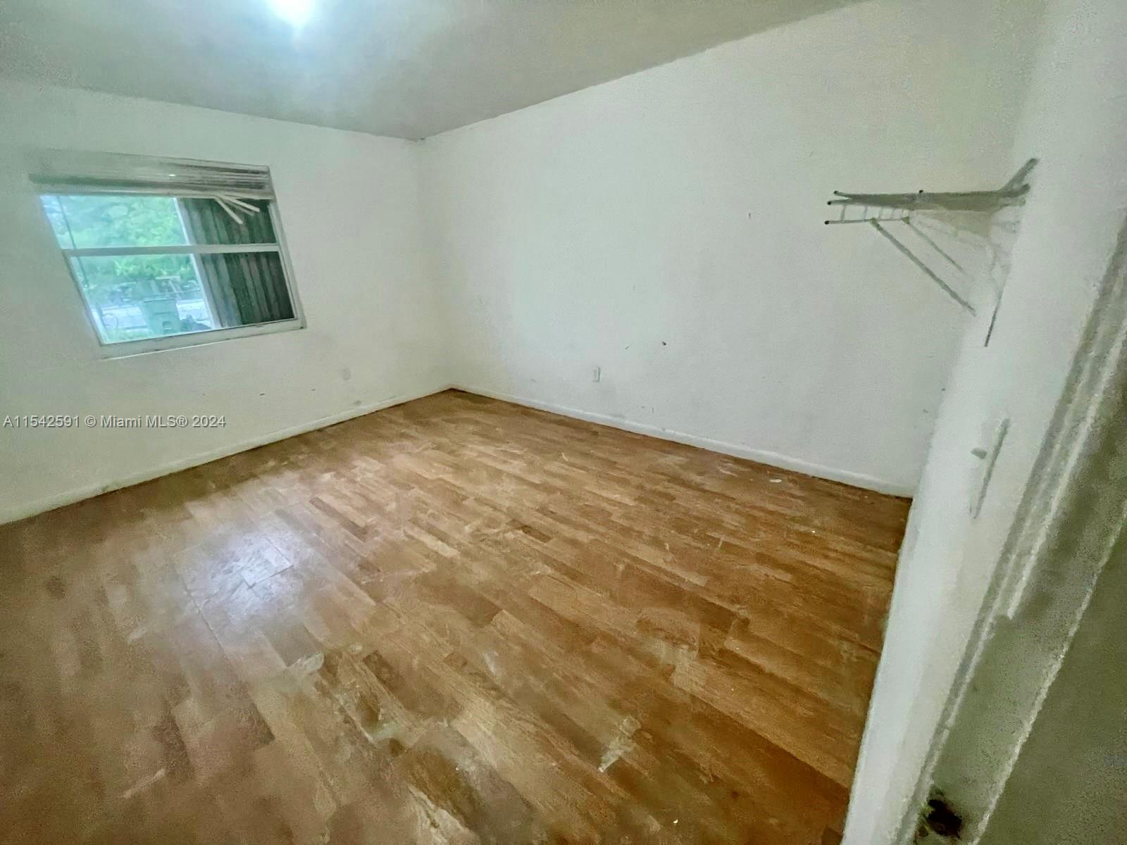 657 Southwest 7th Street Homestead, FL 33030 - Photo 13 of 33 a view of empty room with wooden floor and fan