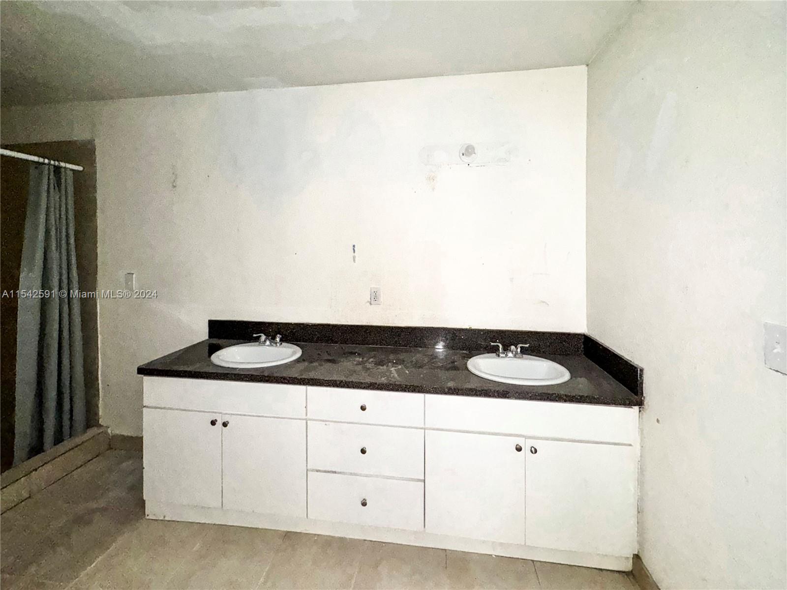 657 Southwest 7th Street Homestead, FL 33030 - Photo 16 of 33 a bathroom with a granite countertop sink and white cabinets