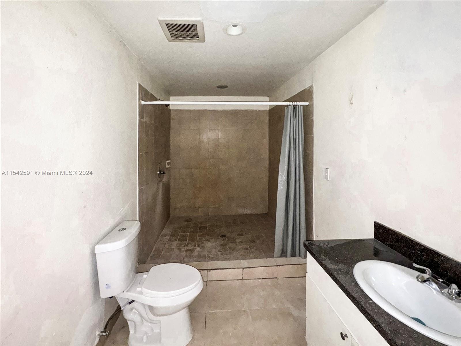 657 Southwest 7th Street Homestead, FL 33030 - Photo 17 of 33 a bathroom with a granite countertop toilet sink and shower