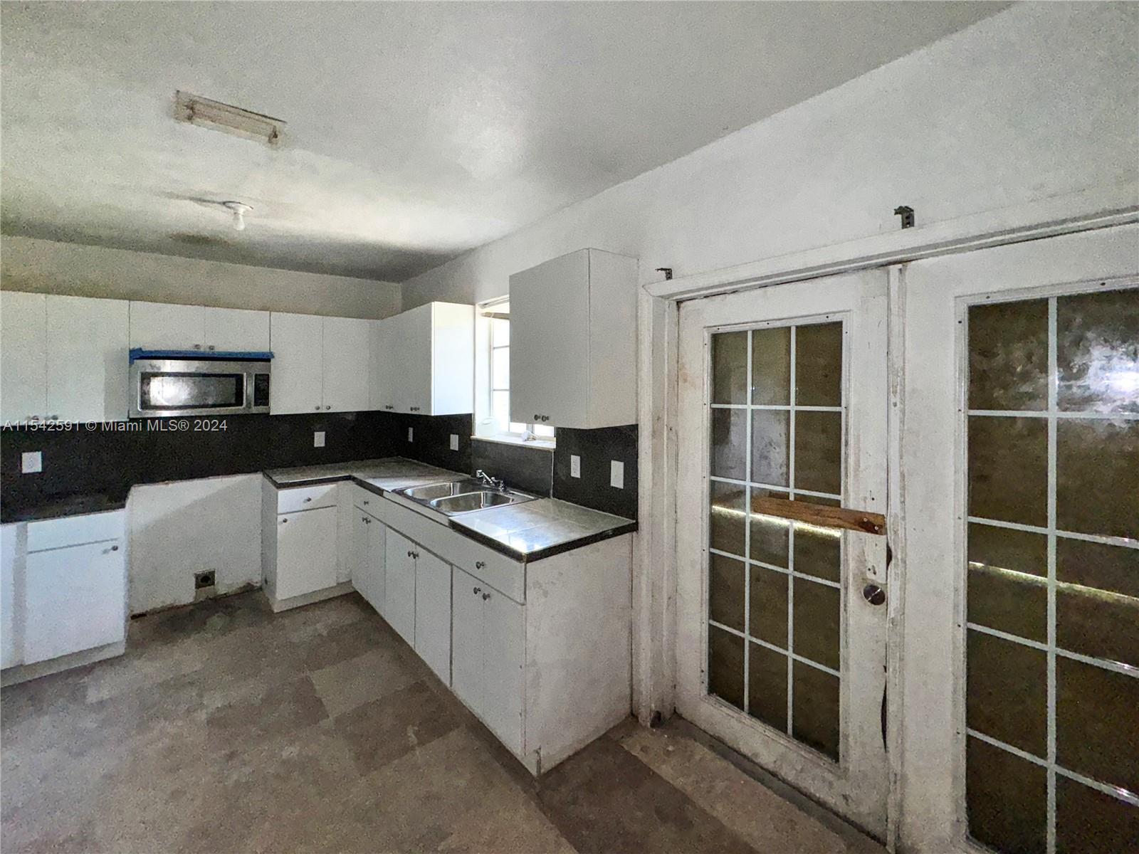 657 Southwest 7th Street Homestead, FL 33030 - Photo 18 of 33 a kitchen with stainless steel appliances granite countertop a stove and a refrigerator