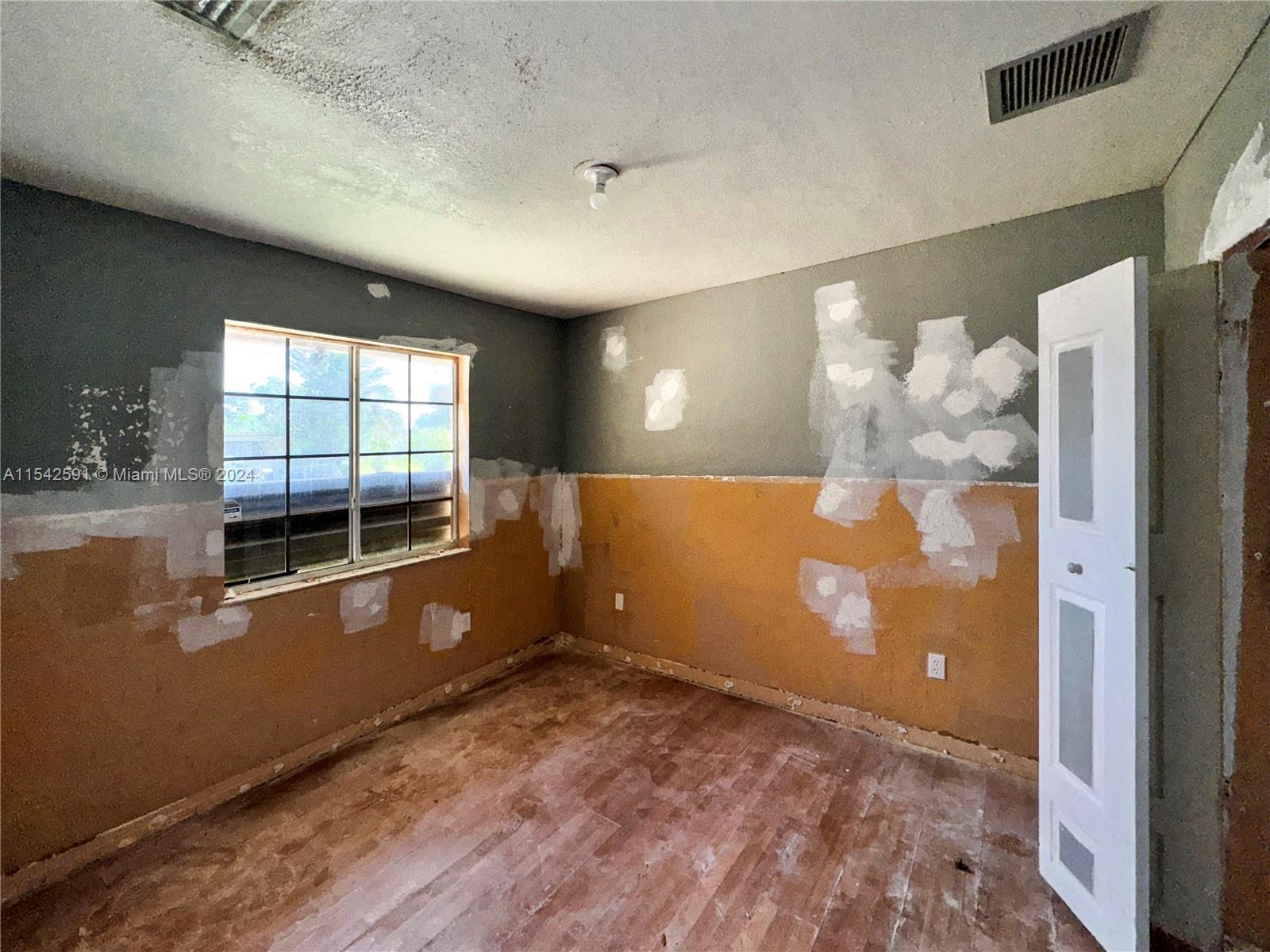 657 Southwest 7th Street Homestead, FL 33030 - Photo 19 of 33 a view of a livingroom with an empty space and a window