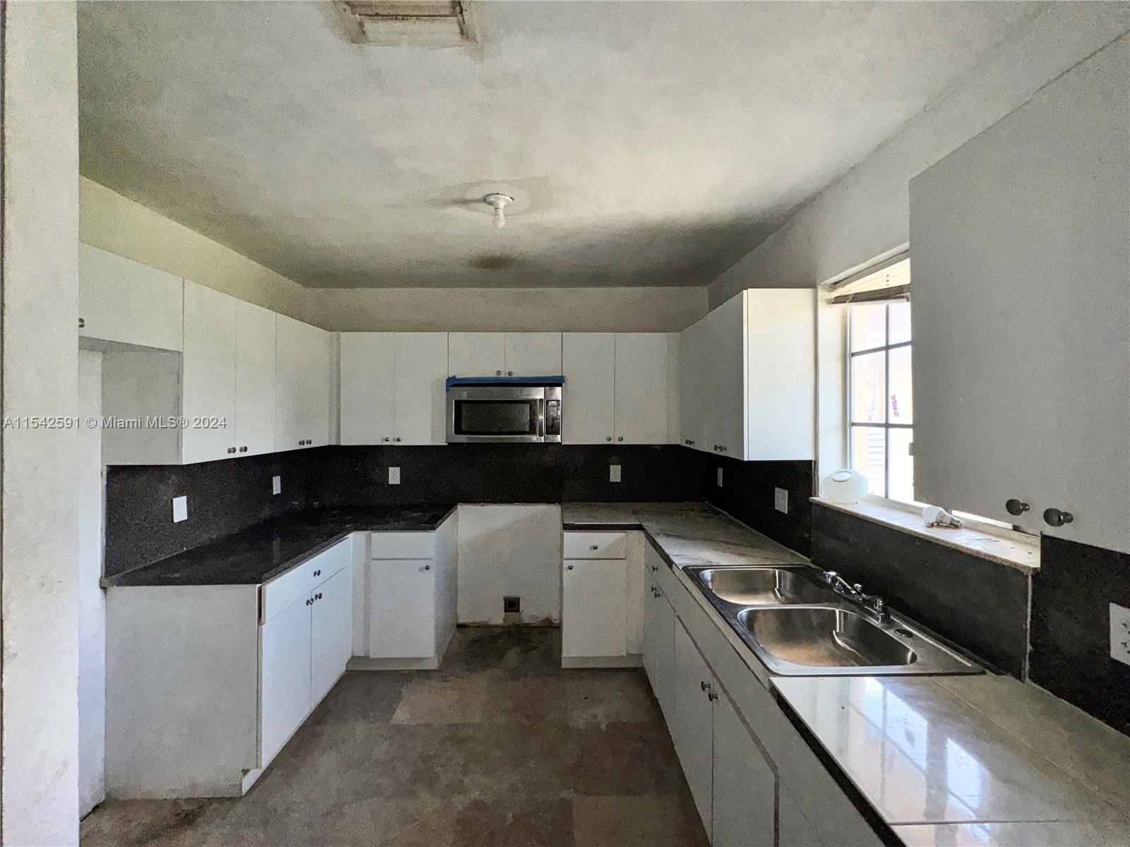 657 Southwest 7th Street Homestead, FL 33030 - Photo 26 of 33 a kitchen that has a sink and a stove
