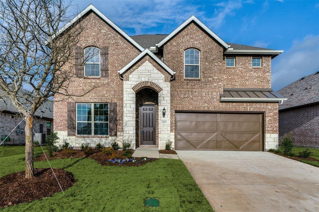 View of front of property featuring a garage and a front yard