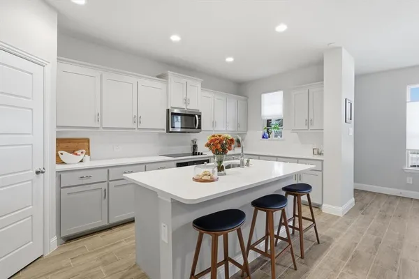 a kitchen with appliances cabinets and wooden floor