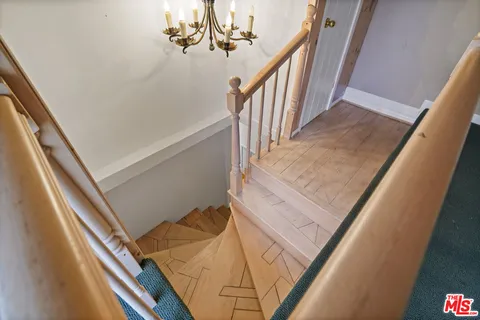 a view of staircase with railing and white walls