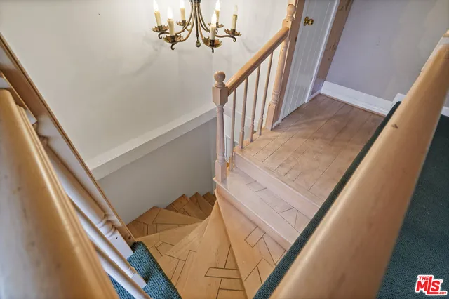 a view of staircase with railing and white walls