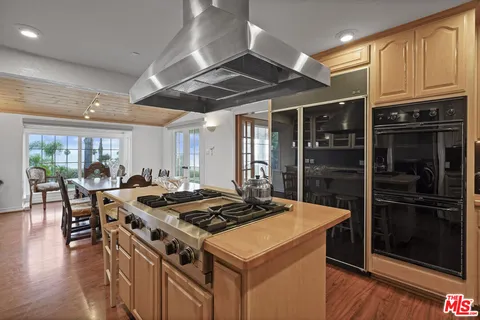 a kitchen with a stove a refrigerator and wooden cabinets