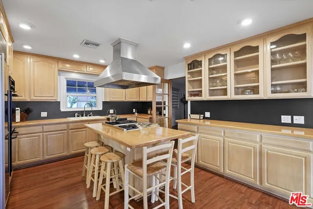 a kitchen with a stove a sink a dining table and chairs