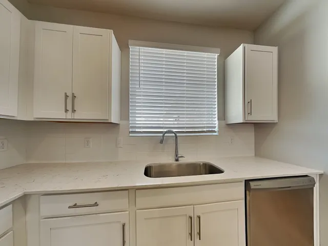 a kitchen with white cabinets and a sink