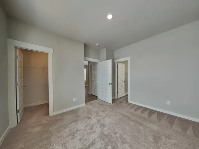 an empty room with closet and a hallway