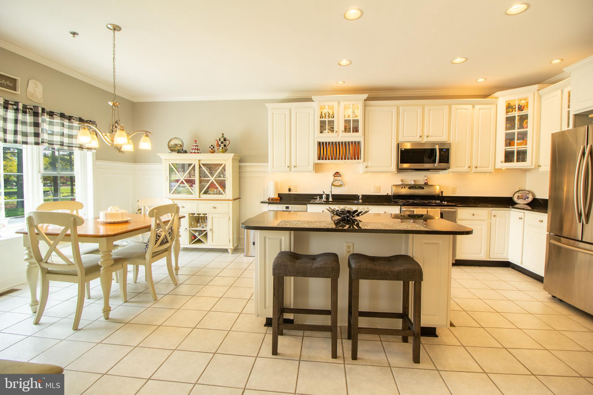 32377 Back Nine Way, Unit 3747 Long Neck, DE 19966 - Photo 13 of 41 a kitchen with stainless steel appliances kitchen island granite countertop a table and chairs in it