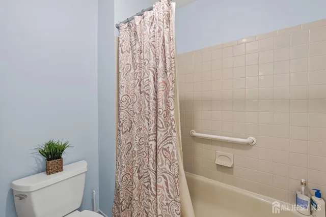 a bathroom with a granite countertop toilet a sink and mirror