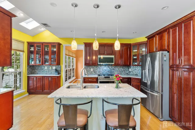 a kitchen with stainless steel appliances granite countertop a sink and a refrigerator