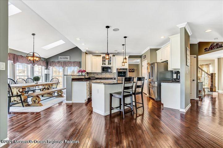 5 Jake Drive Cream Ridge, NJ 08514 - Photo 17 of 64 a kitchen with stainless steel appliances a refrigerator a stove top oven and a dining table with wooden floor