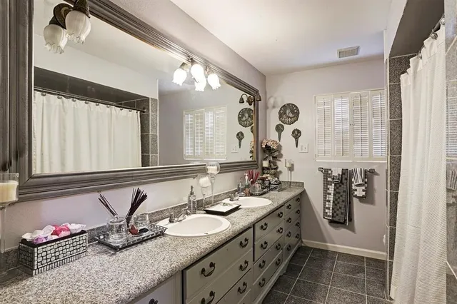 a bathroom with double vanity and a mirror