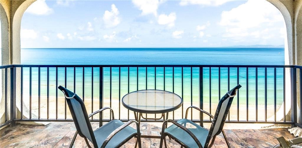 a view of a balcony with furniture and a backyard