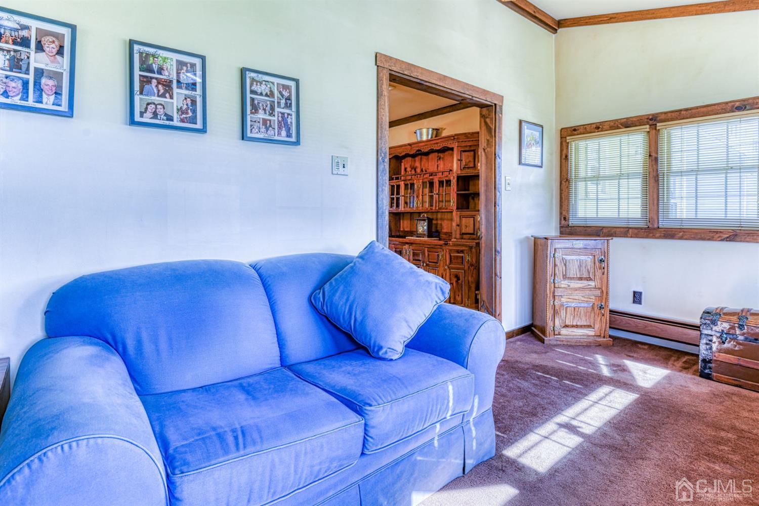 154 East Hill Road Colonia, NJ 07067 - Photo 14 of 25 a blue couch sitting in a living room next to a window