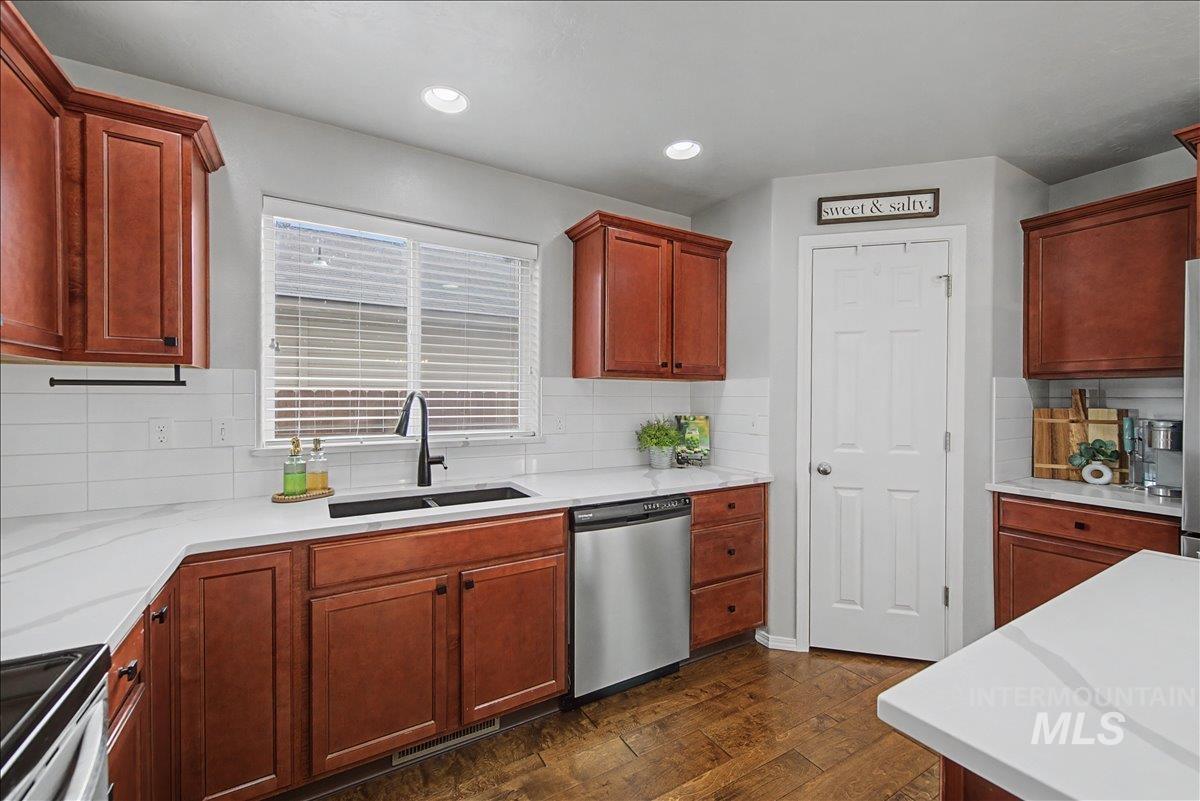 681 West Archerfield Street Meridian, ID 83646 - Photo 12 of 43 Kitchen featuring dishwasher, electric range, dark wood-type flooring, light stone counters, and recessed lighting