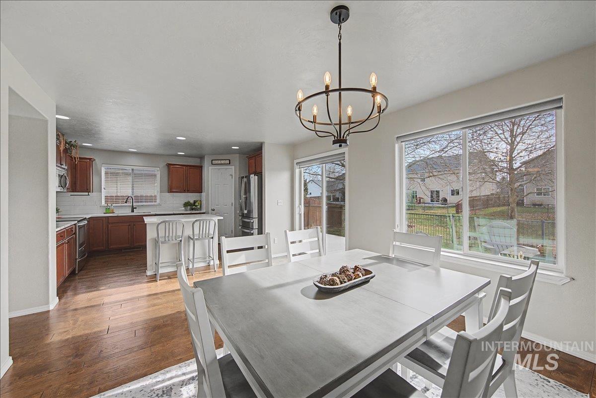 681 West Archerfield Street Meridian, ID 83646 - Photo 19 of 43 Dining space with dark wood-style flooring, recessed lighting, and a chandelier
