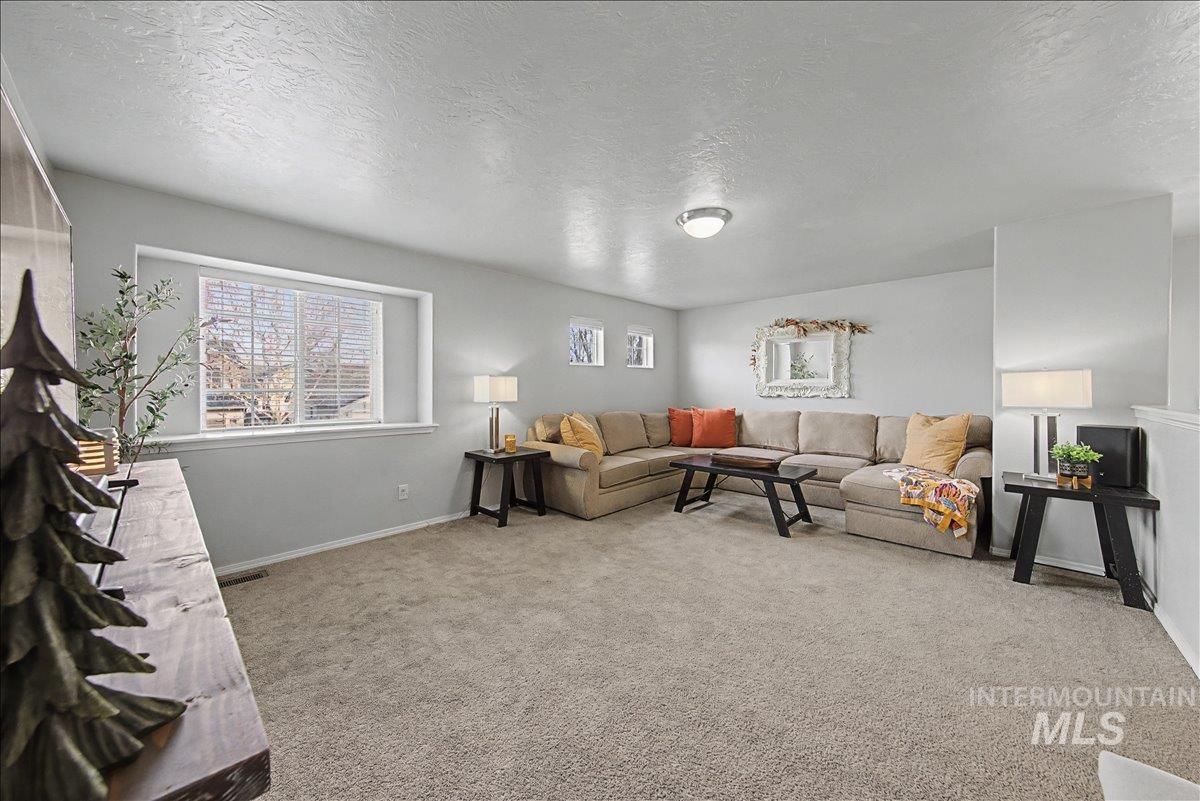 681 West Archerfield Street Meridian, ID 83646 - Photo 27 of 43 Living area featuring a textured ceiling and light colored carpet