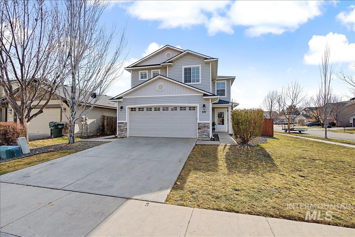 681 West Archerfield Street Meridian, ID 83646 - Photo 3 of 43 View of front of home with stone siding, driveway, a front yard, a residential view, and board and batten siding