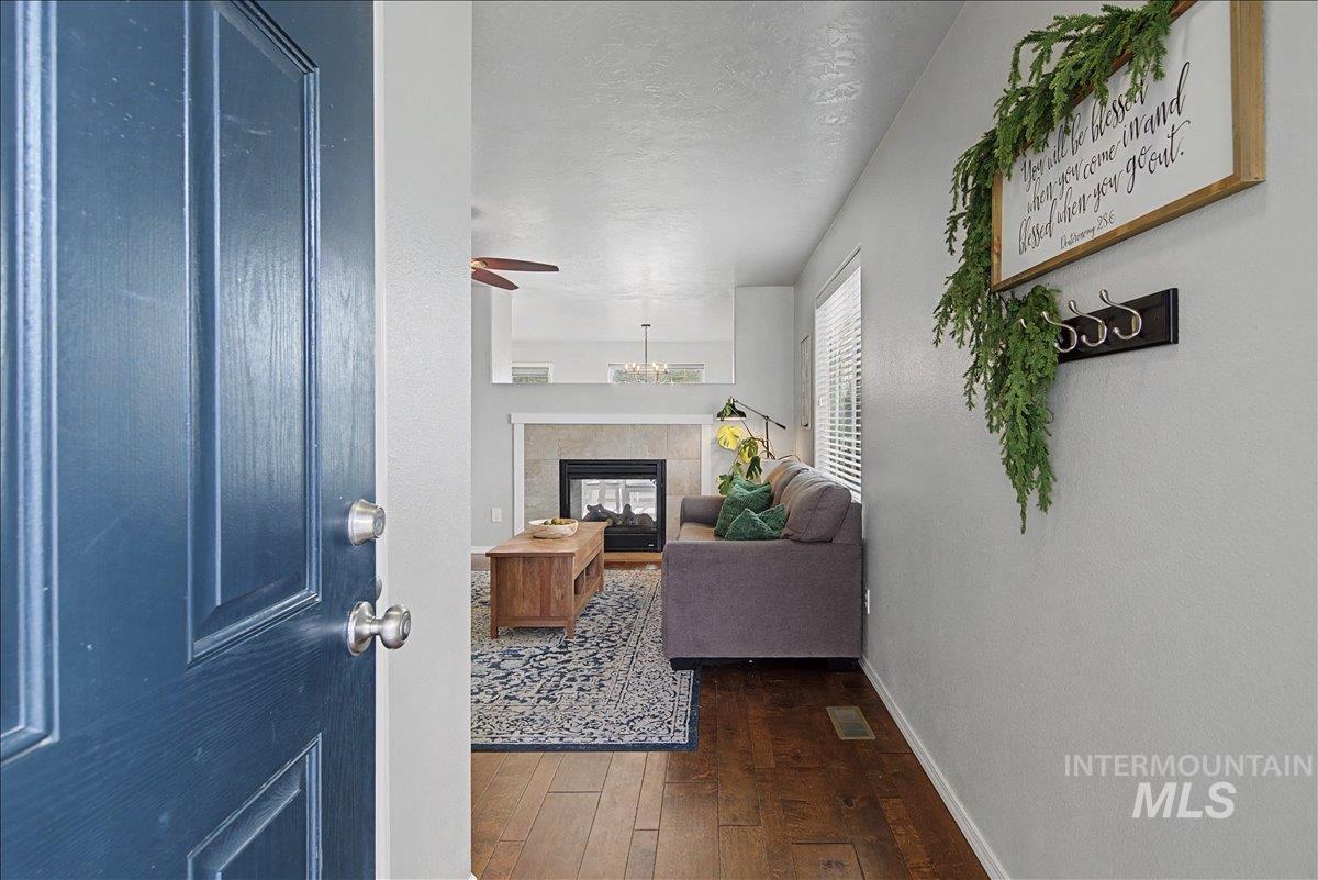 681 West Archerfield Street Meridian, ID 83646 - Photo 5 of 43 Entryway with a textured ceiling, dark wood-type flooring, and a tiled fireplace