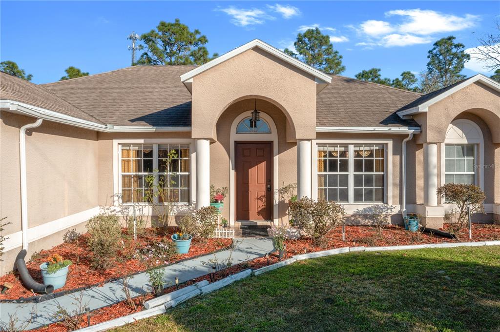 27 Vinca Street Homosassa, FL 34446 - Photo 2 of 50 a front view of a house with garden