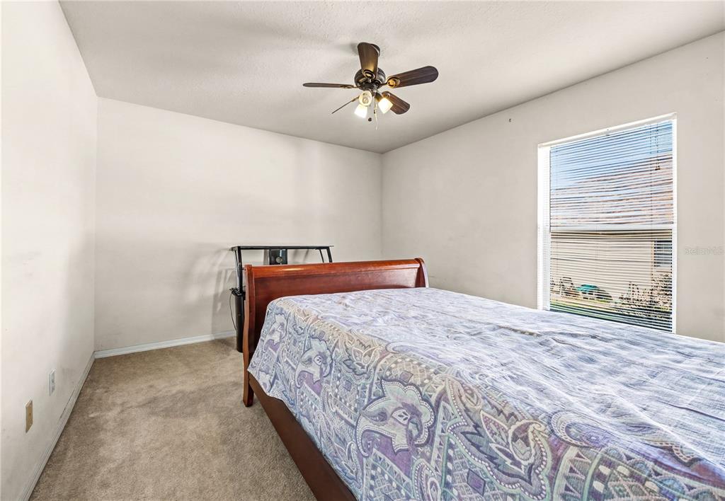 27 Vinca Street Homosassa, FL 34446 - Photo 22 of 50 a bedroom with a large bed and a ceiling fan