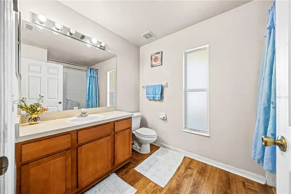 a spacious bathroom with a sink a toilet and a mirror