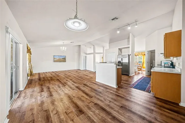 a view of kitchen with refrigerator and wooden floor