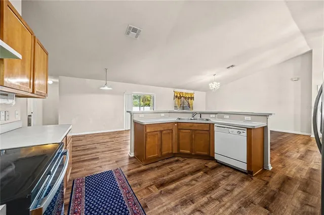 a kitchen with stainless steel appliances granite countertop a stove a sink and a microwave