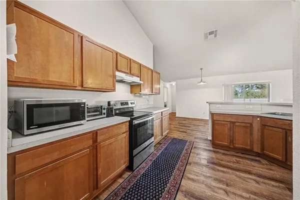 a kitchen with stainless steel appliances granite countertop a sink a stove and a refrigerator