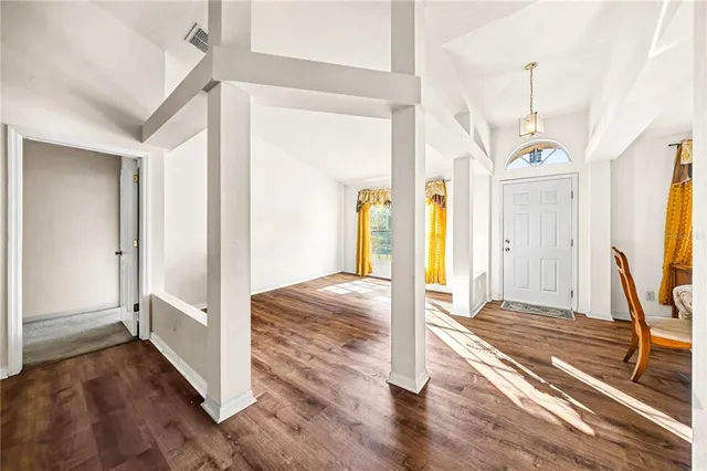 a view of a big room with wooden floor and windows