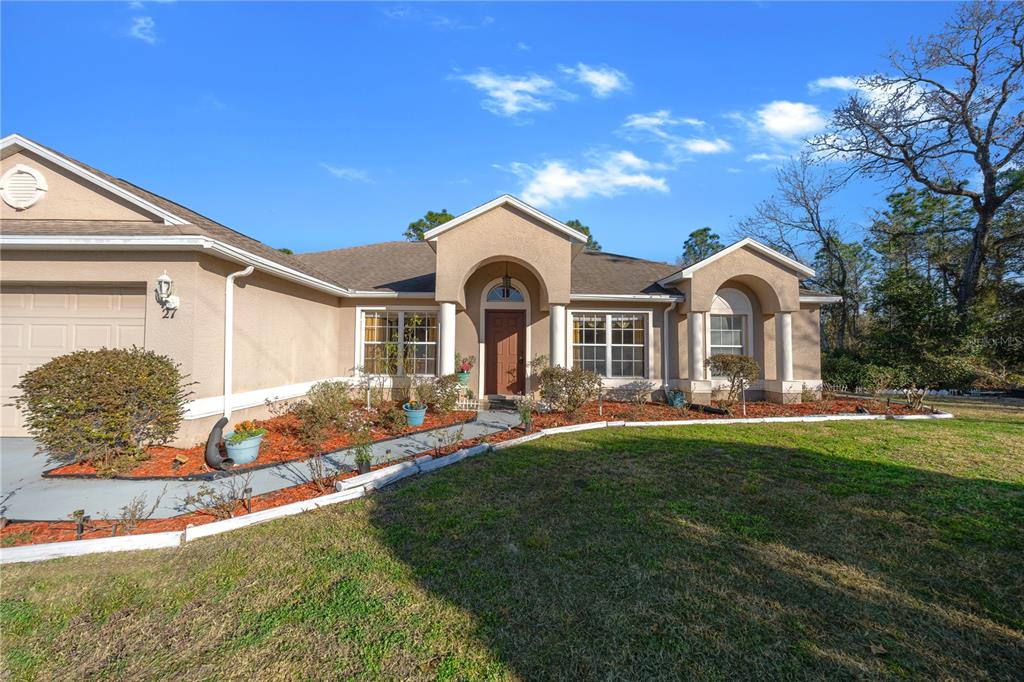 27 Vinca Street Homosassa, FL 34446 - Photo 5 of 50 a front view of a house with a garden