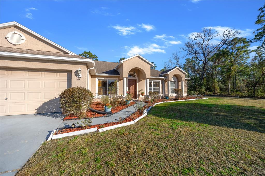 27 Vinca Street Homosassa, FL 34446 - Photo 6 of 50 a front view of a house with garden