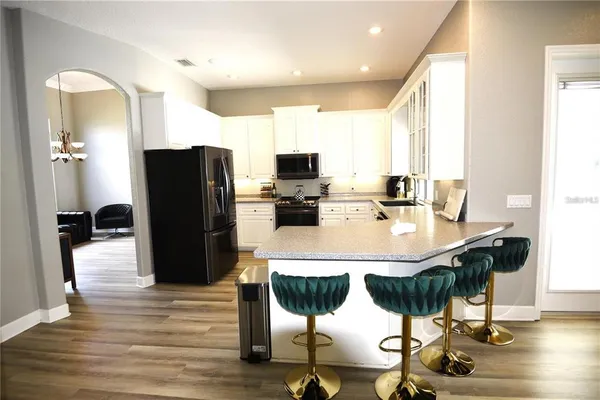 a kitchen with stainless steel appliances kitchen island granite countertop a refrigerator and cabinets