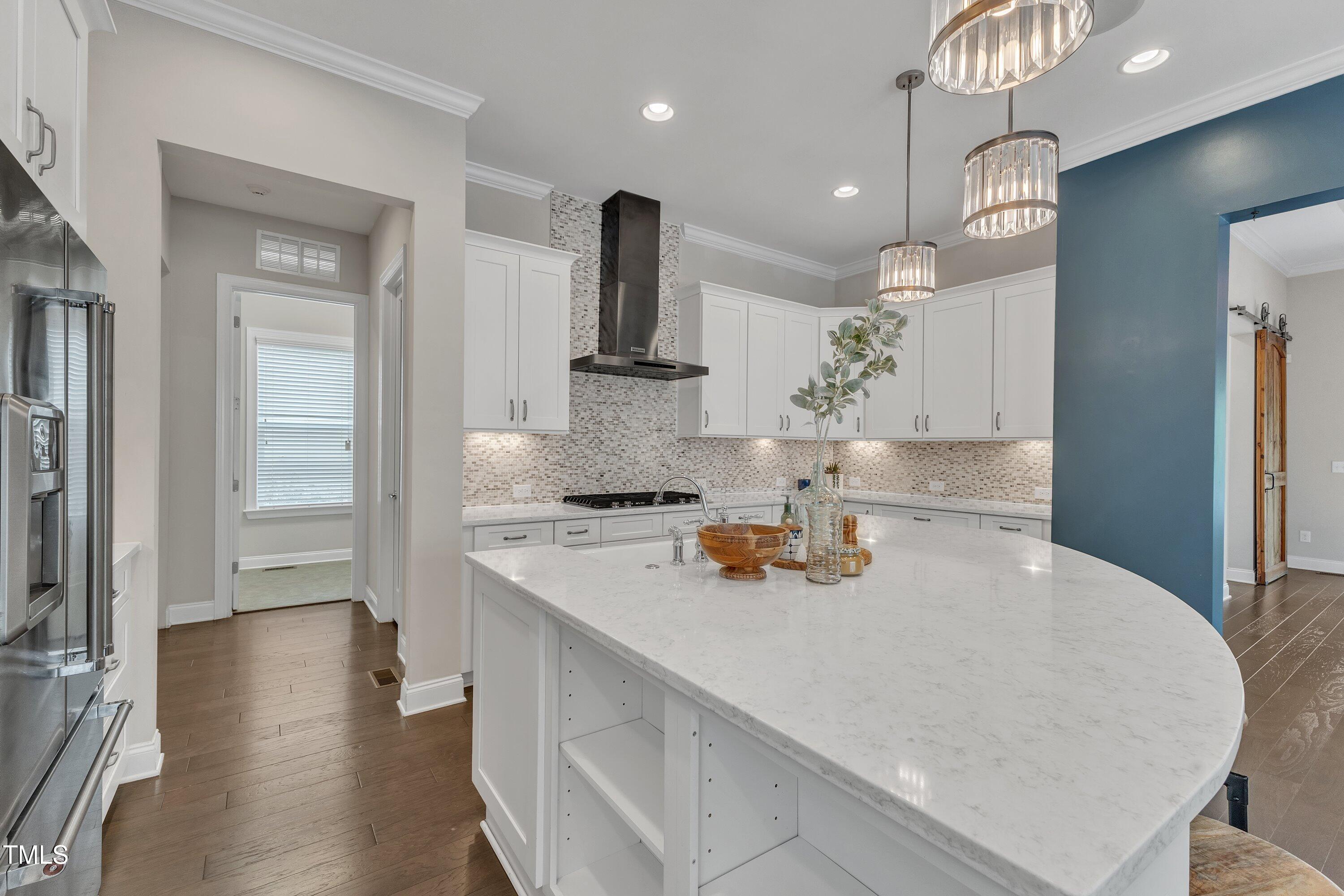 8121 Greys Landing Way Raleigh, NC 27615 - Photo 21 of 95 a kitchen with stainless steel appliances a sink a stove and a wooden floor