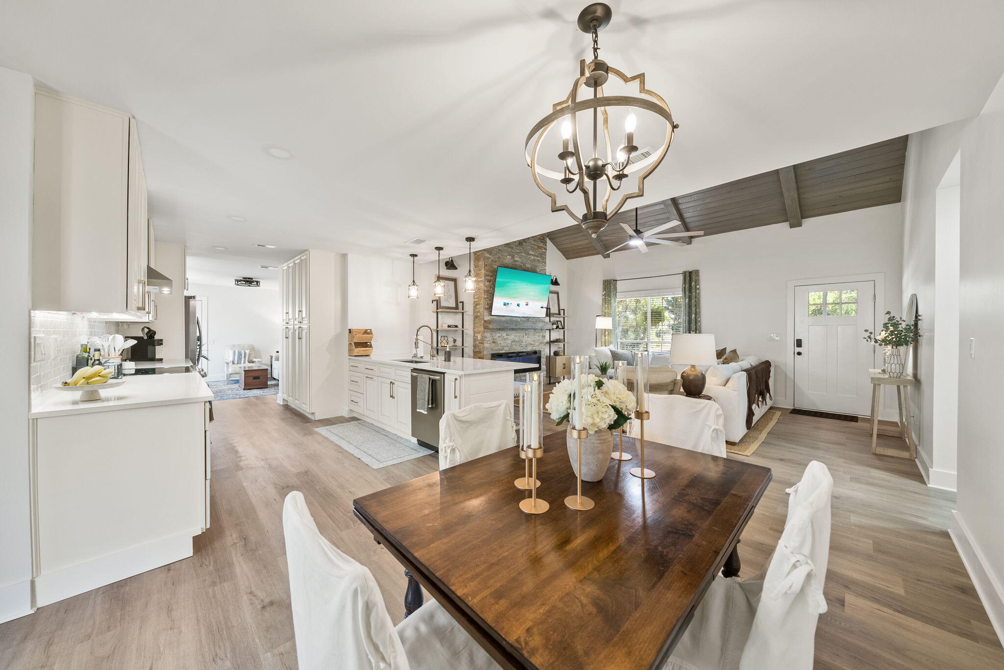 1045 Don Bishop Road Santa Rosa Beach, FL 32459 - Photo 13 of 37 a view of a dining room and livingroom with furniture wooden floor a chandelier