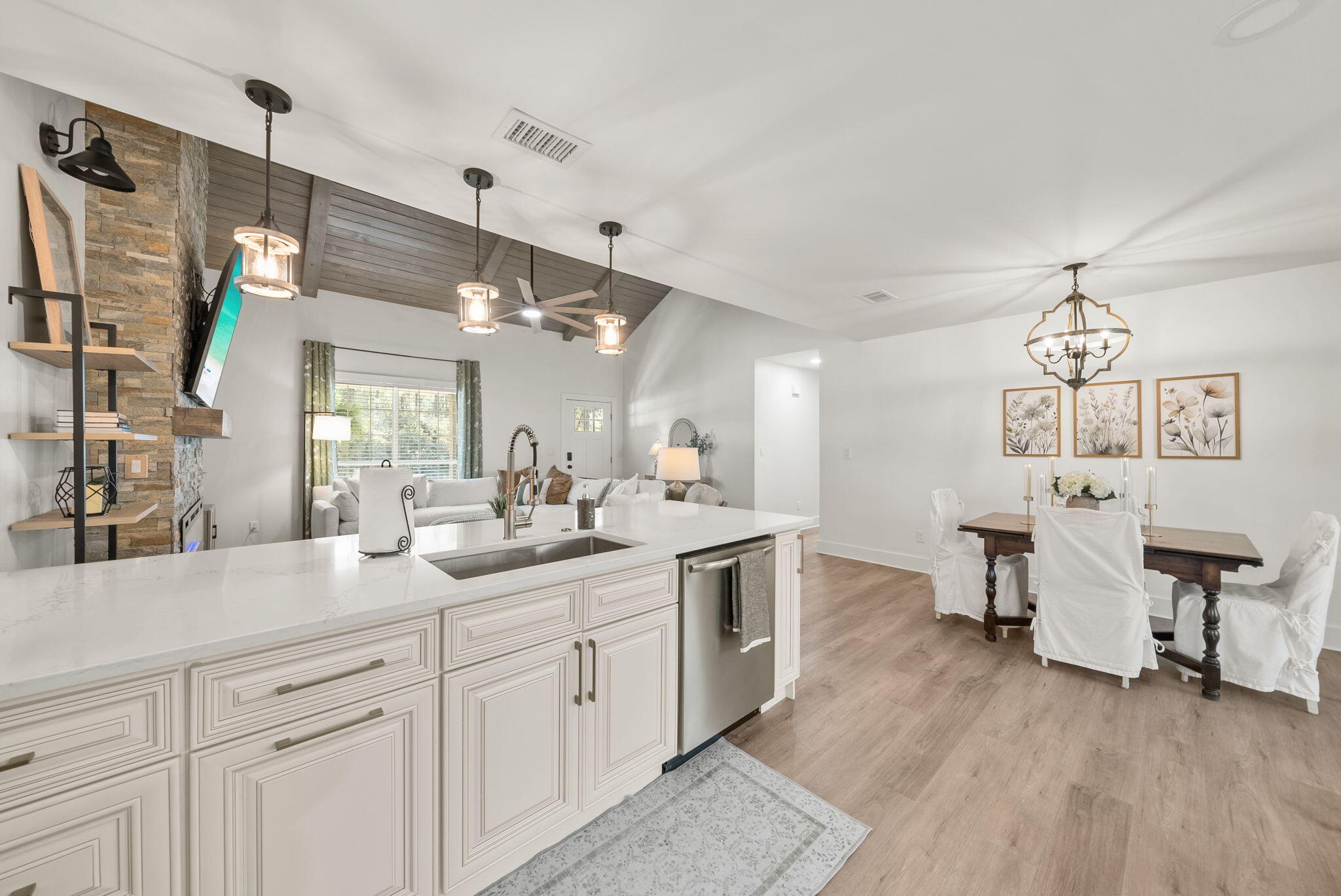 1045 Don Bishop Road Santa Rosa Beach, FL 32459 - Photo 14 of 37 a open kitchen with a sink dishwasher a dining table and chairs with wooden floor