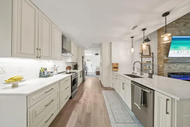 a large kitchen with a lot of counter space and wooden floor