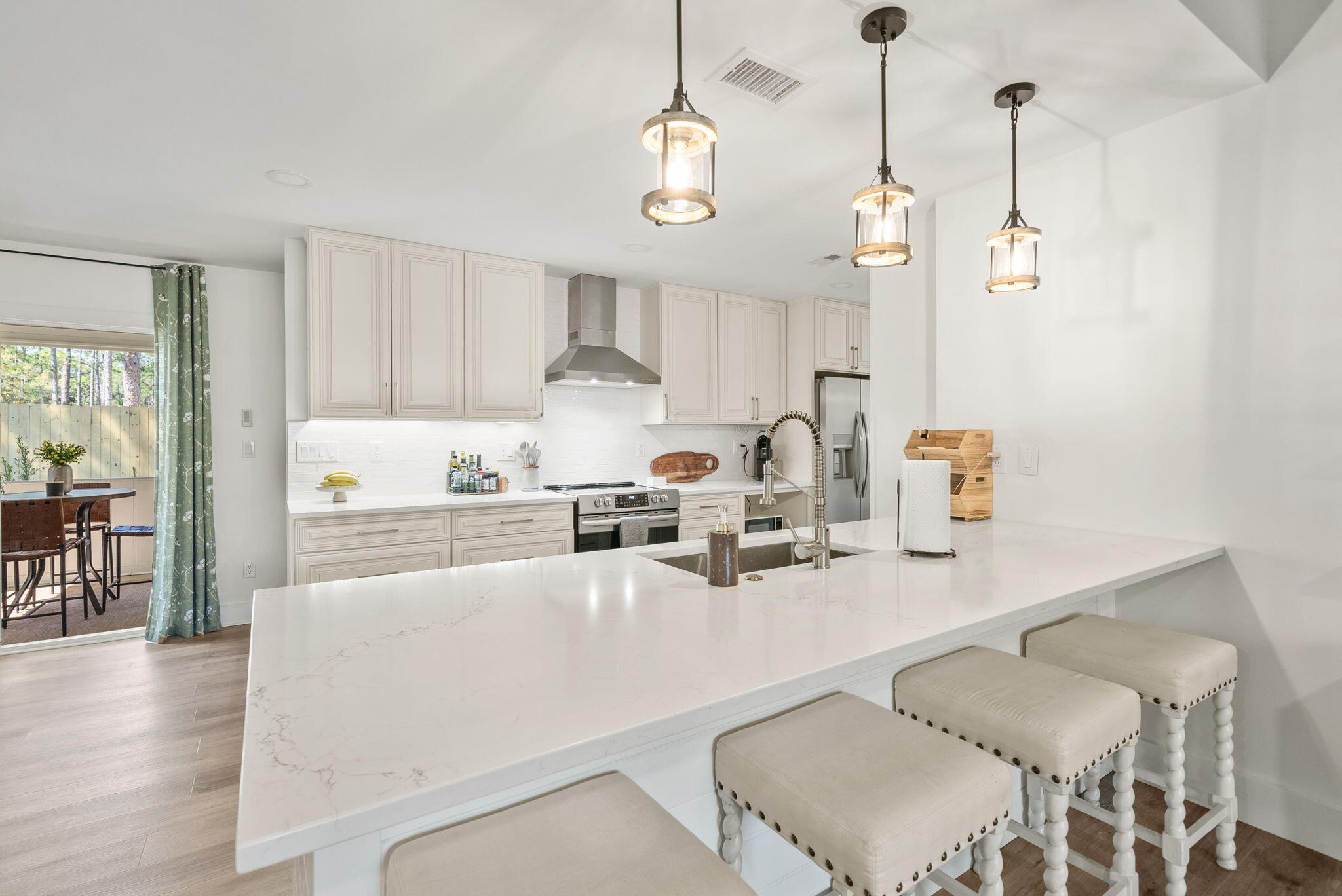 1045 Don Bishop Road Santa Rosa Beach, FL 32459 - Photo 16 of 37 a kitchen with stainless steel appliances granite countertop a sink a stove a dining table and chairs with wooden floor