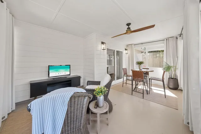 a living room with furniture a flat screen tv and a large window