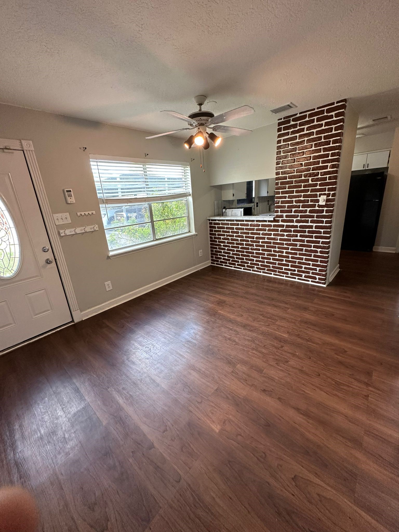 7305 South Gessner Road Houston, TX 77036 - Photo 16 of 24 an empty room with wooden floor chandelier fan and windows