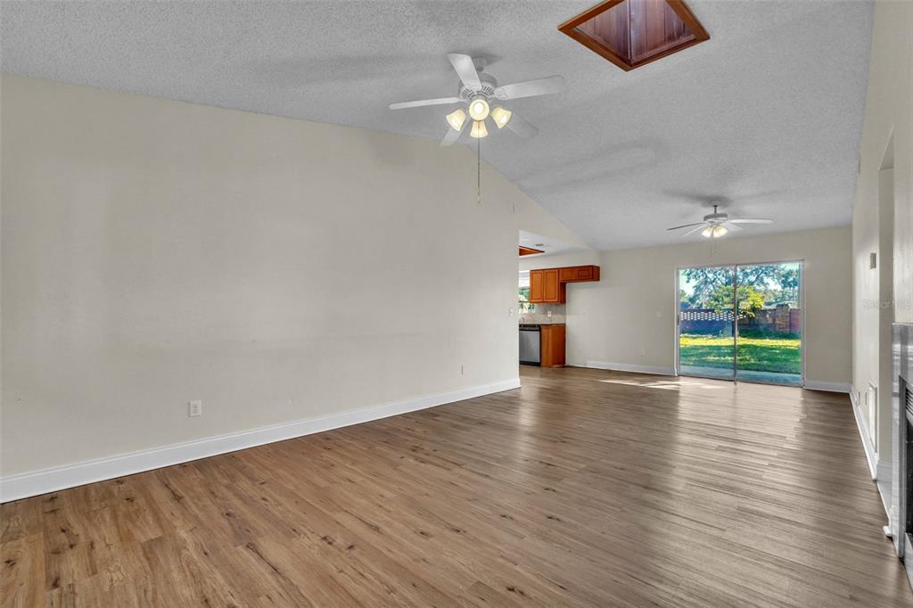 7724 Pengrove Pass Orlando, FL 32835 - Photo 13 of 24 a view of an empty room with wooden floor and a chandelier