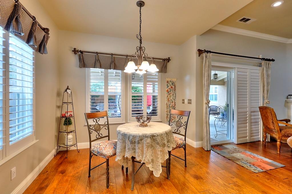 4152 Post Oak Drive Turlock, CA 95382 - Photo 34 of 71 a dining room with furniture a chandelier and wooden floor