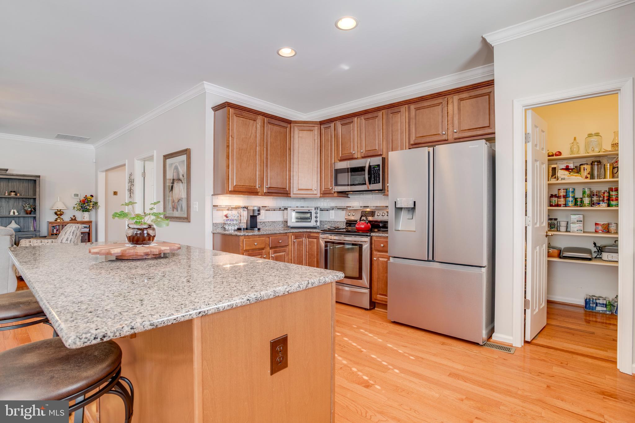 9408 Blackbird Loop Culpeper, VA 22701 - Photo 15 of 89 a kitchen with stainless steel appliances granite countertop a refrigerator a stove a sink a dining table and chairs