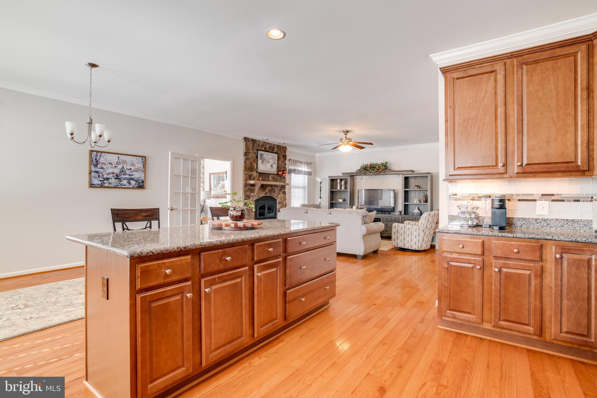 9408 Blackbird Loop Culpeper, VA 22701 - Photo 17 of 89 a large kitchen with kitchen island granite countertop a stove a sink dishwasher and cabinets with wooden floor