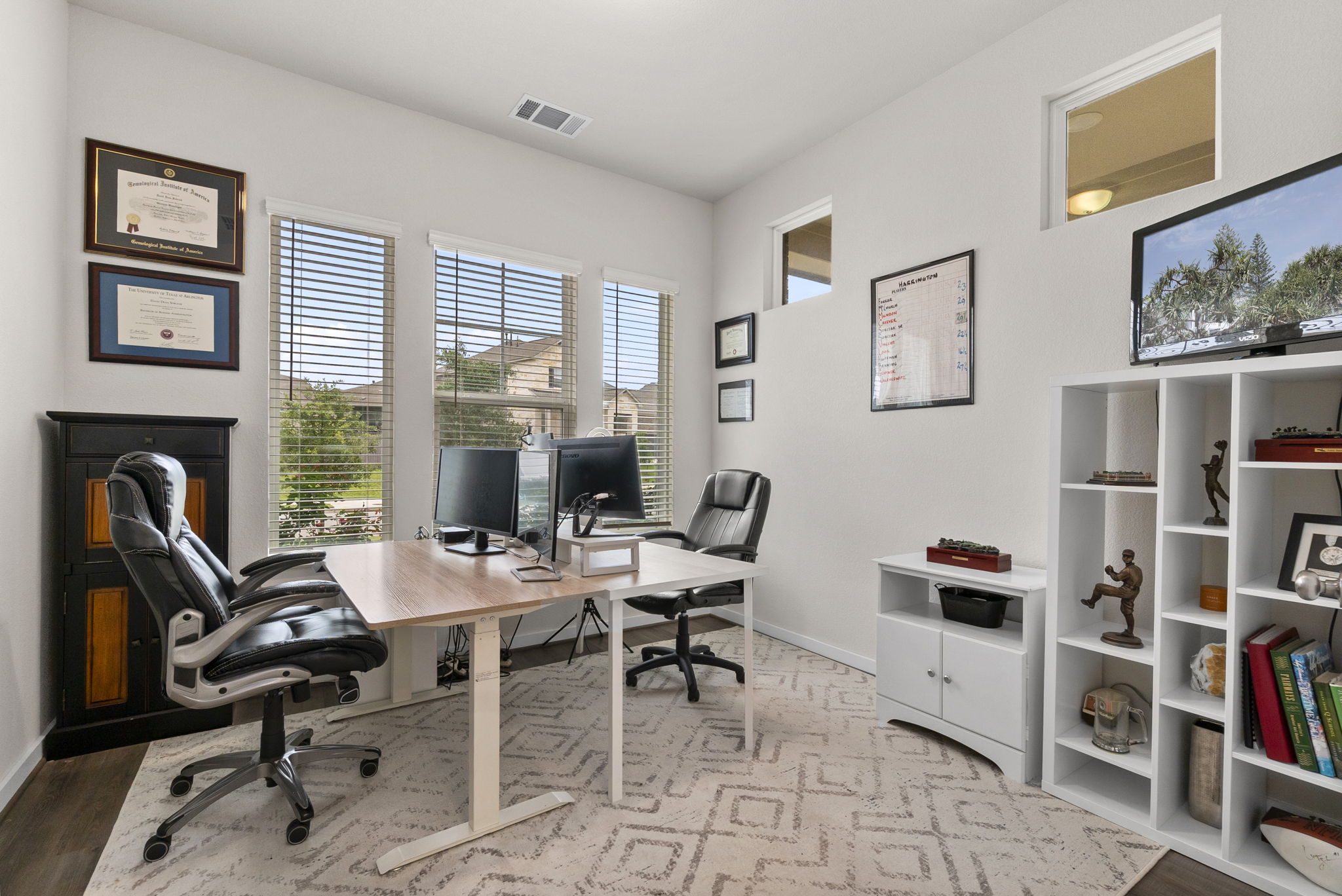 460 Constitution Way Kyle, TX 78640 - Photo 16 of 40 Spacious room featuring wood-finish flooring, multiple windows with blinds, a built-in black storage cabinet, and white walls
